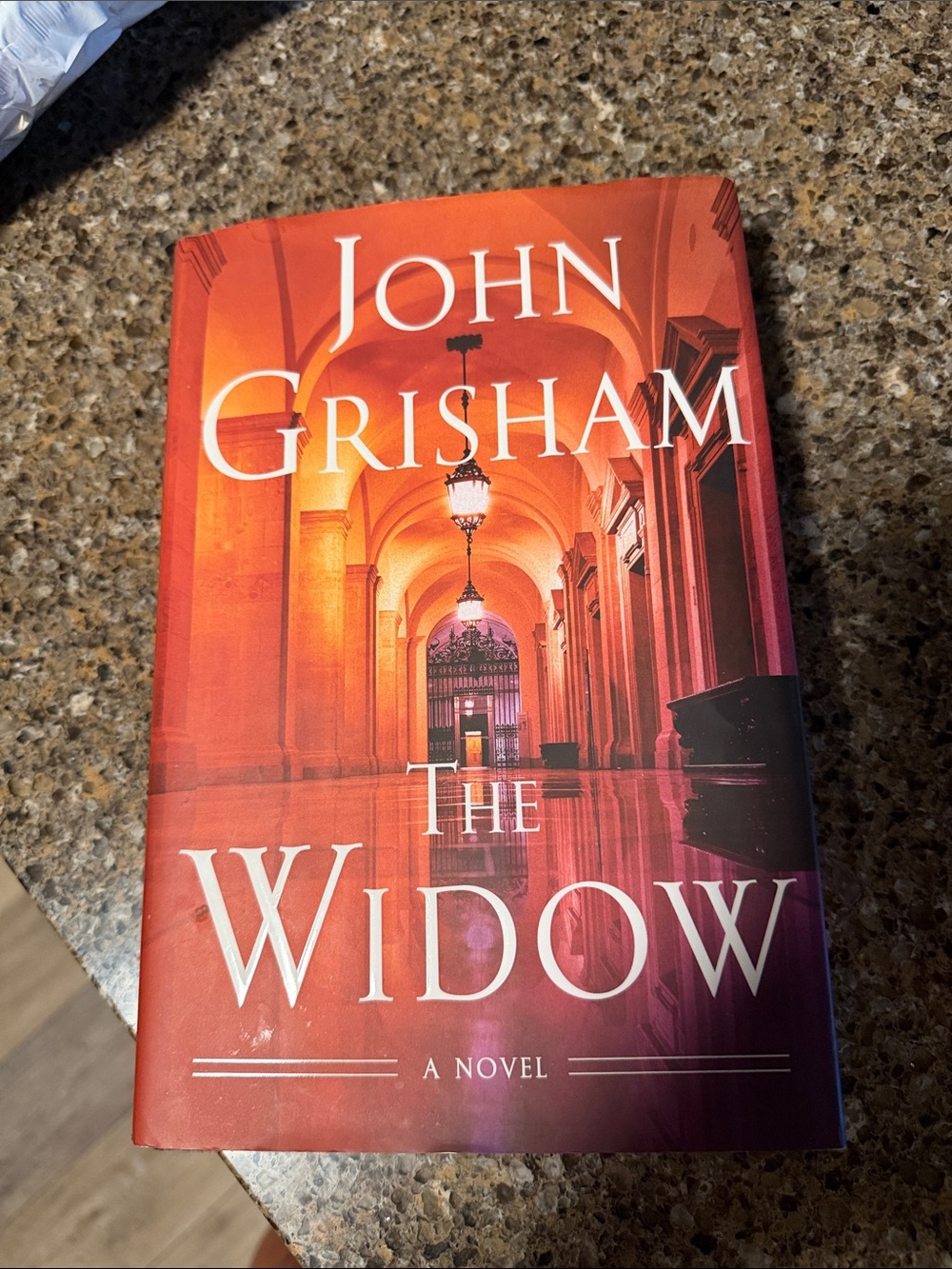 Calling all John Grisham fans. The Widow Hardcover Novel - Red/Orange Cover